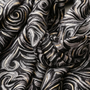 Gros plan d'un châle épais en satin coton lin avec imprimé spirale doré et texture