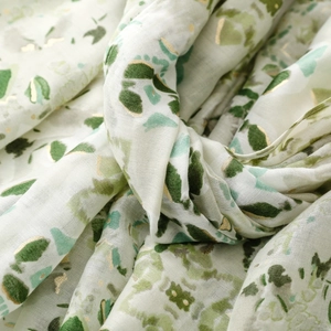 Texture dell'etichetta verde floreale con stampa a lamina d'oro su tessuto leggero