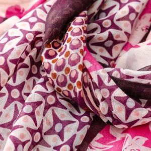 Detailed close-up of bohemian floral scarf fabric showing purple star patterns and soft texture