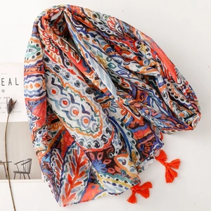 Bohemian paisley print scarf with orange tassels on a minimalist white background
