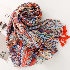Detail of bohemian paisley floral scarf featuring vibrant orange fringe and soft texture