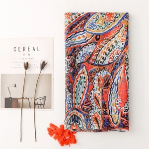 Bohemian paisley scarf with orange tassels and colorful floral patterns for travel