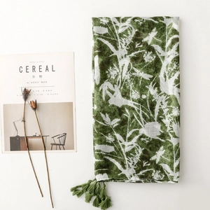 Detail of green floral scarf with white dragonfly patterns and decorative tassels