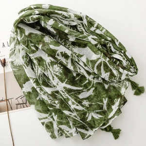 Detail of dark green floral print scarf featuring delicate fringe tassels and lightweight fabric