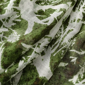 Close-up of vintage floral scarf fabric showing dark green leaf prints and soft texture