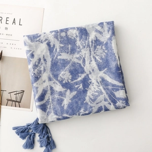 Detail of blue and white floral print scarf with elegant matching tassel edges