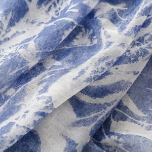 Detailed macro view of blue and white Toile de Jouy pattern on cotton linen fabric