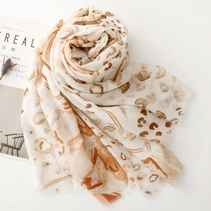 Detail of elegant leopard print scarf with fringe edges next to Cereal magazine