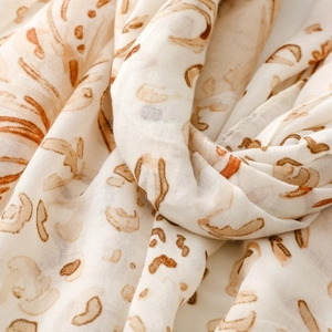 Close-up of lightweight satin scarf with gold leopard print and floral texture