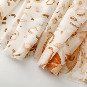 Close-up of leopard floral satin scarf showing soft folds and frayed fringe edges