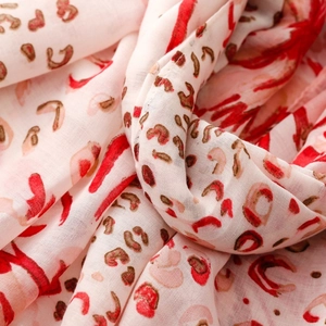 Detail of red leopard print scarf fabric showing soft drape and breathable texture