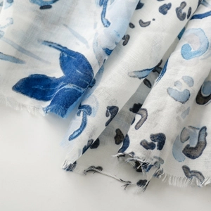 Detail of thin blue leopard floral scarf showing raw edge fringe and sheer texture