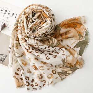 Detail of thin satin scarf with leopard print and floral pattern on white background