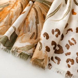 Macro detail of leopard and floral print scarf with soft fringe edges and fabric texture