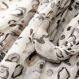 Detailed close-up of leopard print scarf fabric showing soft folds and fiber texture