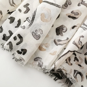 Macro view of leopard print scarf fabric with soft texture and delicate frayed edges