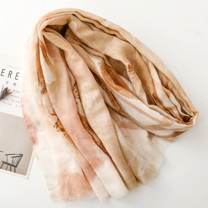 Detail of glitter marble pattern scarf with soft fringe edges and golden shimmer texture