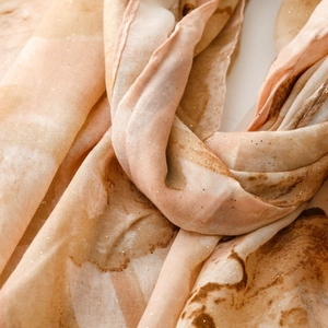 Macro detail of silk scarf showing golden glitter accents and abstract iris floral texture