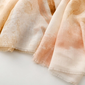 Close-up of lightweight gradient satin scarf with gold foil accents and fringe