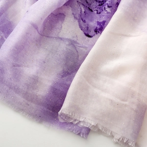 Detail of purple gradient silk scarf featuring gold foil print and fine fringe edges