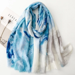 Blue and white tie-dye scarf with gold foil accents and fringe, displayed on white background