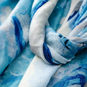 Detail of blue watercolor scarf featuring delicate gold foil speckles and fine texture