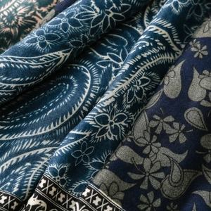 Macro shot of paisley pattern fabric showing luxurious silk texture and teal blue prints