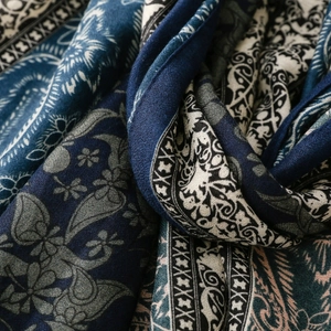 Detail of soft fabric folds showing paisley print and floral patterns on blue shawl