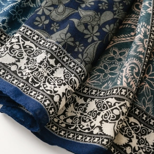 Close-up of navy blue and white paisley print scarf with intricate floral patterns