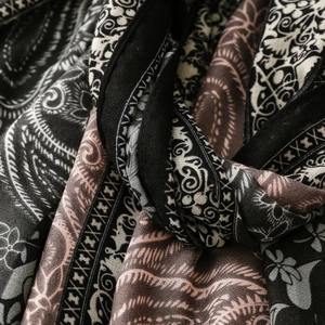 Macro view of paisley print on lightweight woven fabric with soft draped texture