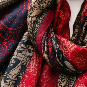 Detail shot of bohemian paisley scarf with intricate patterns in red and navy blue