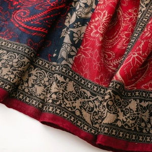 Close-up of paisley and floral patterns on soft red and blue fabric with fine textures