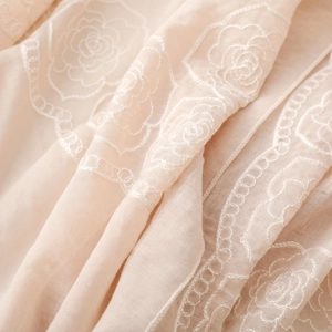 Close-up of white rose embroidery on light beige breathable ethnic style scarf