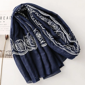 Close-up of navy blue scarf with white rose embroidery and elegant floral patterns