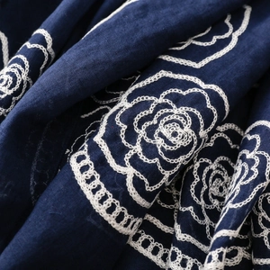 Detailed close-up of white rose embroidery on navy ethnic style cotton linen scarf fabric