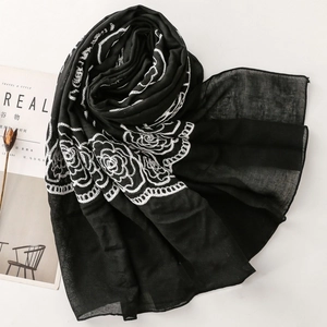 Detail of delicate white rose floral embroidery on lightweight black ethnic scarf