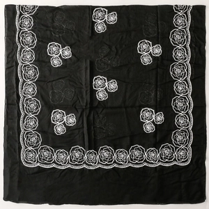 Detail of elegant black shawl with white rose floral embroidery and fringe trim borders