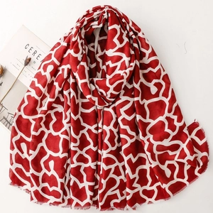 Sciarpa con stampa geometrica rossa e bianca e bordi con frange su sfondo bianco