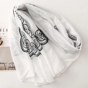 Detailed embroidery of black roses on a lightweight white ethnic style shawl scarf