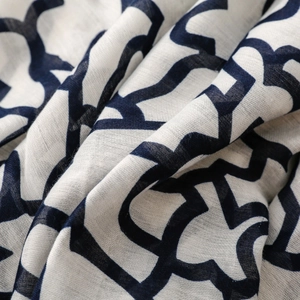 Vista macro del tessuto in cotone e lino bianco con motivo geometrico blu navy morbido