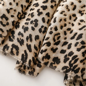 Macro view of leopard print cotton linen scarf featuring soft texture and raw frayed edges