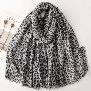 Elegant leopard print scarf with fringe edges displayed on a minimalist white background