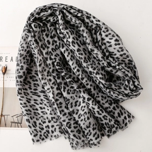 Close-up of leopard print scarf with frayed edges on minimalist magazine background