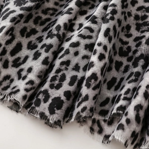 Close-up of leopard print cotton linen scarf with soft frayed edges and tassels