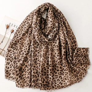 Leopard print scarf with fringe edges displayed on a minimalist lifestyle background