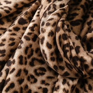 Macro shot of leopard print scarf showing fine woven texture and soft fringed edges