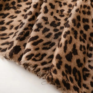 Close-up of leopard print scarf featuring soft cotton-linen texture and raw fringe edges