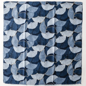 Detail shot of navy blue scarf featuring dense ginkgo leaf print and delicate frayed edges