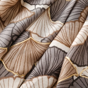 Detailed view of soft linen-touch fabric with golden ginkgo leaf foil print patterns