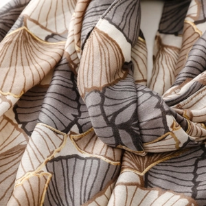 Detail of soft cotton linen scarf with gold foil ginkgo leaf print and textured fabric